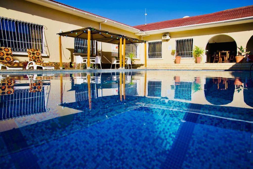 una piscina frente a una casa en BOUGAINVILLA Boutique Hotel & Restaurant en Lubumbashi