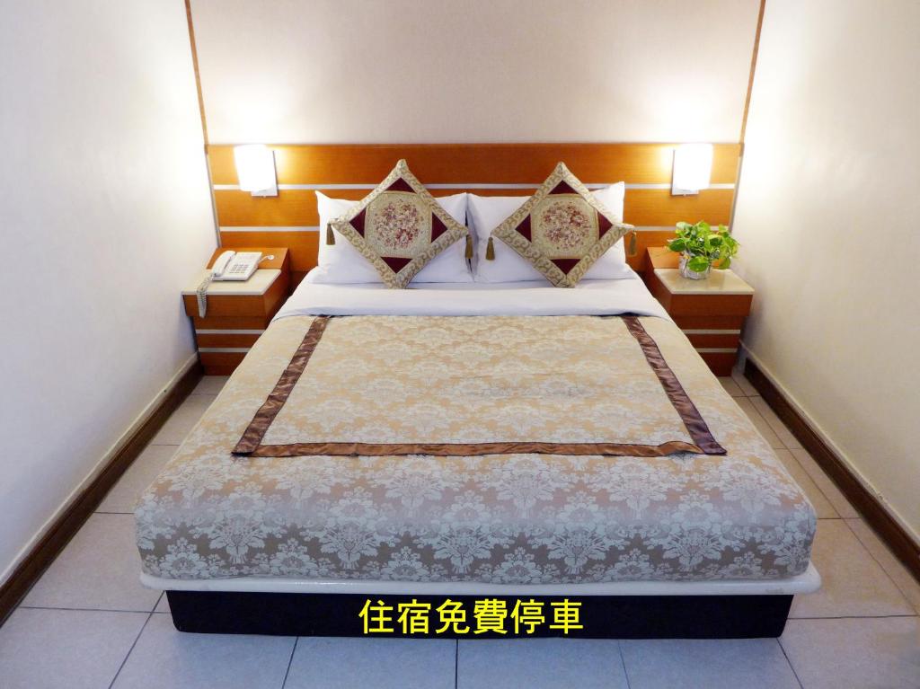 a bedroom with a bed with two pillows at Hua Guo Hotel in Keelung