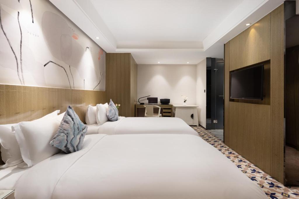 Postel nebo postele na pokoji v ubytování Paco Hotel Gangding Metro Guangzhou-Free Shuttle Bus fir Canton Fair