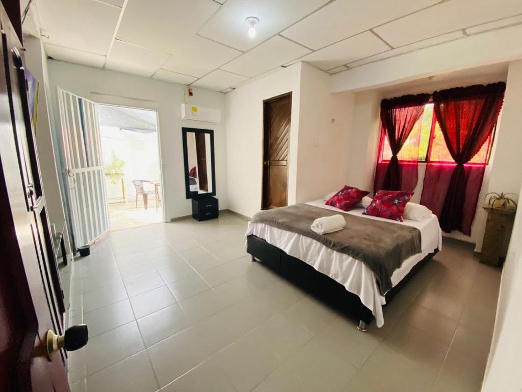Un dormitorio con una cama con almohadas rojas. en LA Perla Sabanera CTG, en Cartagena de Indias