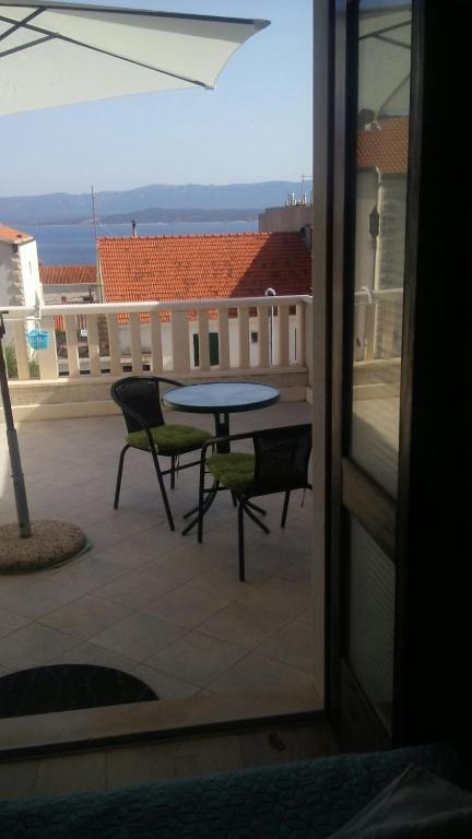 a patio with a table and chairs on a balcony at Sea view room in Bol