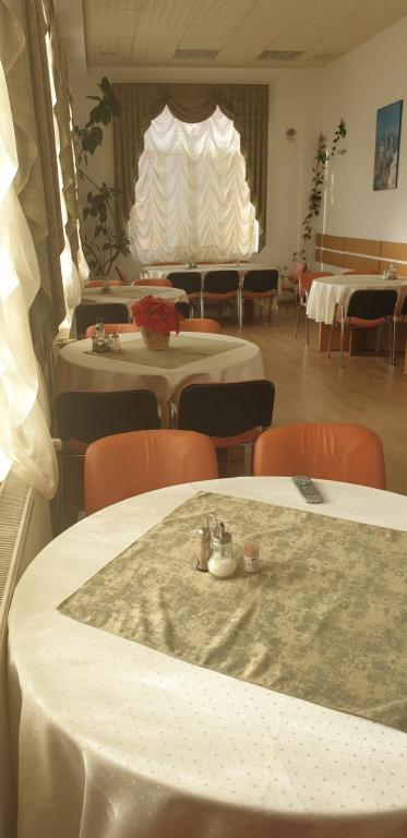 a room with tables and chairs and a room with tables and chairs at Pensiunea Confort in Buşteni