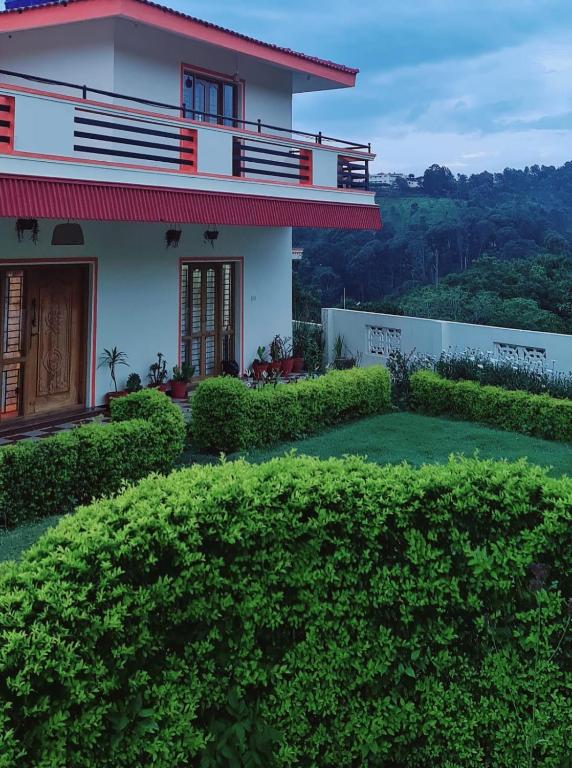 a house on a hill with green bushes at Hidden Heaven in Coonoor