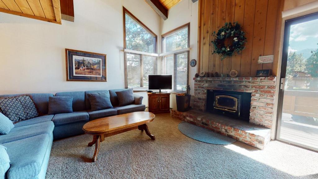 a living room with a blue couch and a fireplace at Wild Flower 42 Apartment in Mammoth Lakes
