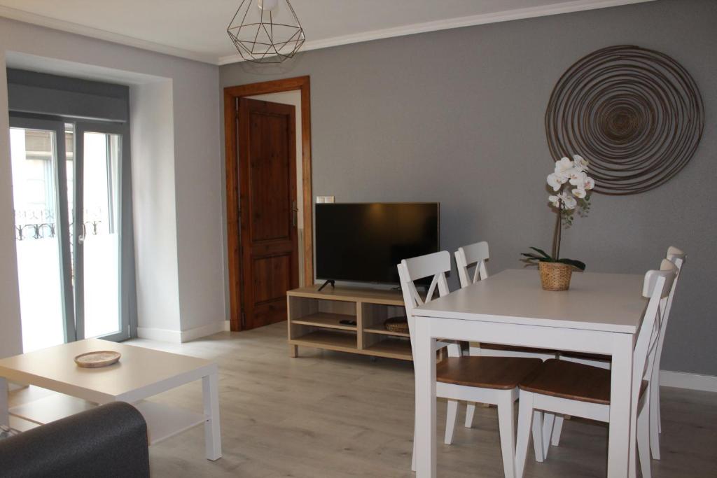 sala de estar con mesa blanca y TV en Apartamento Estiviellas, Pirineo, en Jaca