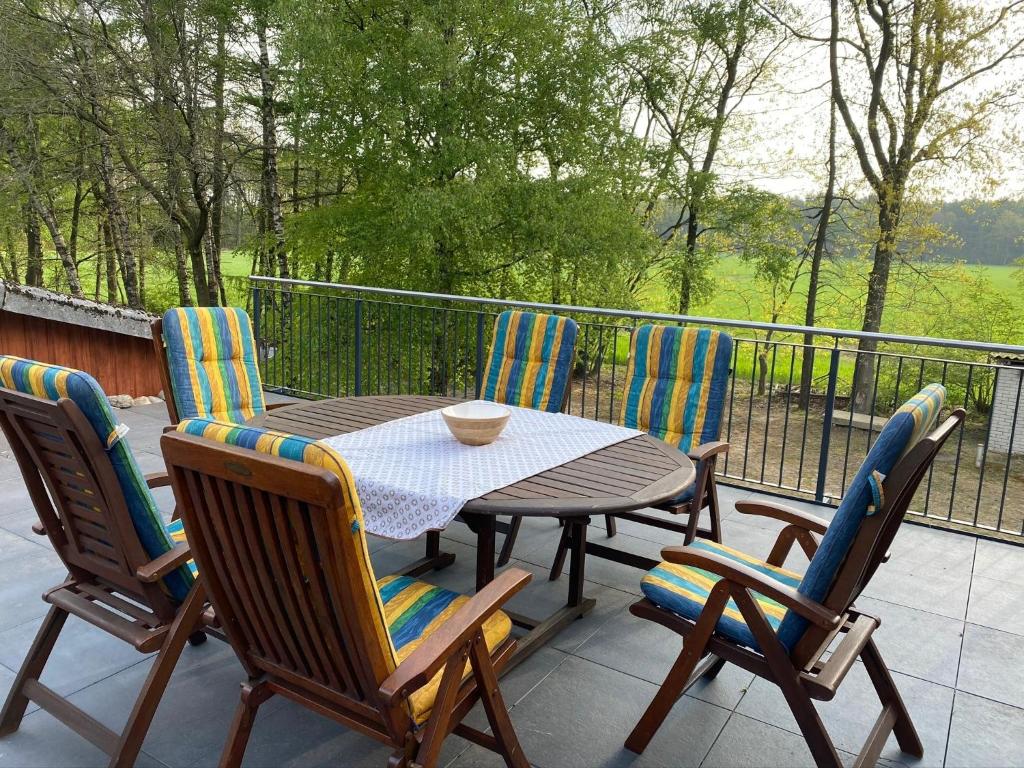 - une table et des chaises en bois sur une terrasse avec vue dans l'établissement Ferienhof Thele Wohnung OG, à Werlte