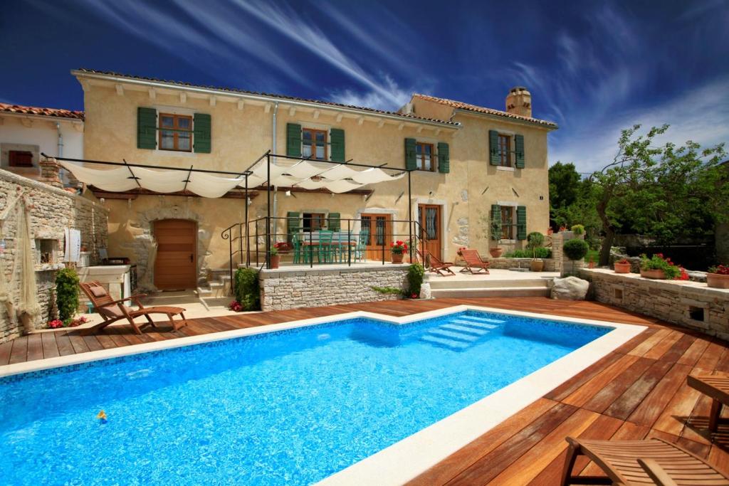 a villa with a swimming pool in front of a house at Villa Gelci in Trget