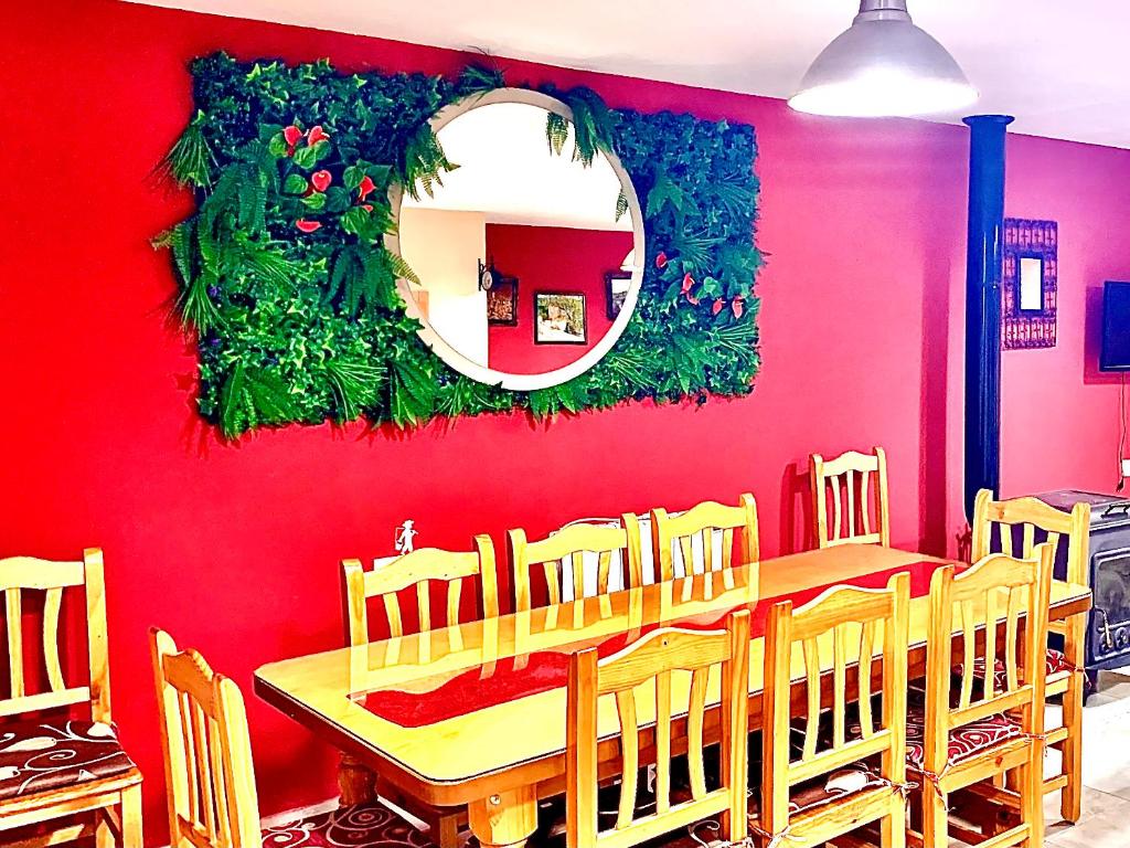 a dining room with a red wall and a table and chairs at Casa Rural Bekirent in Bocairent