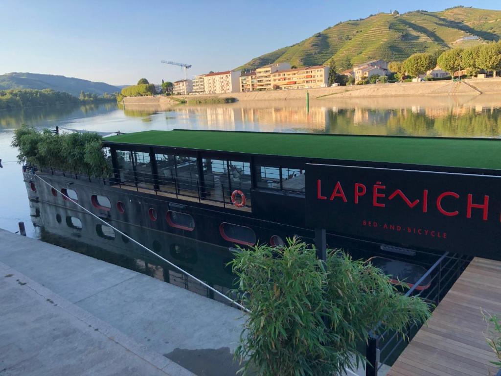 um barco está ancorado ao lado de um rio em LA PENICHE - Bed And Bicycle - Tournon em Tournon-sur-Rhône