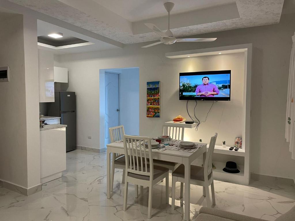 a dining room with a table and a tv on a wall at CASA MARAVILLOSA in Bayahibe