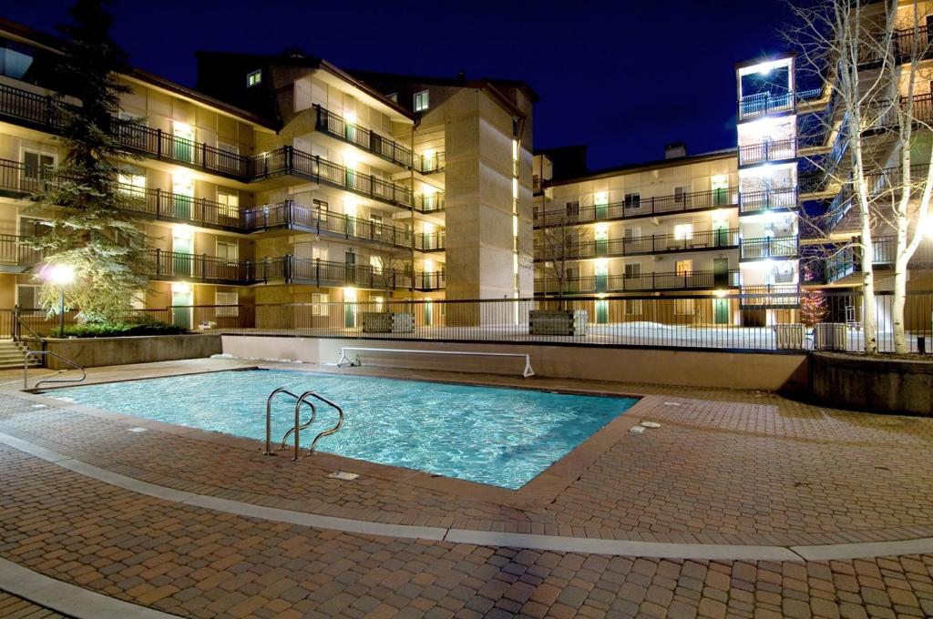 a swimming pool in front of a building at night at Vantage Point 112 Condo in Vail