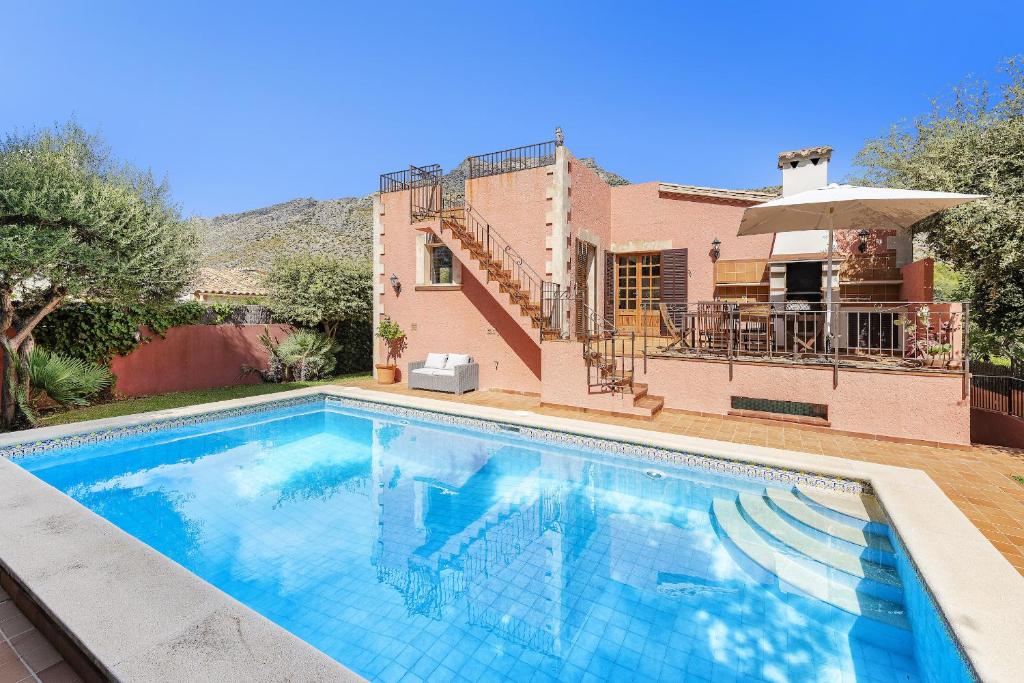 a swimming pool in front of a house at Villa Ramis by JS Villas in Cala de Sant Vicenc