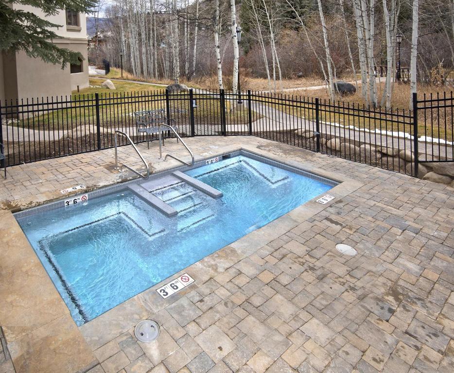 a swimming pool in a yard next to a fence at Townsend Place A107 Condo in Beaver Creek