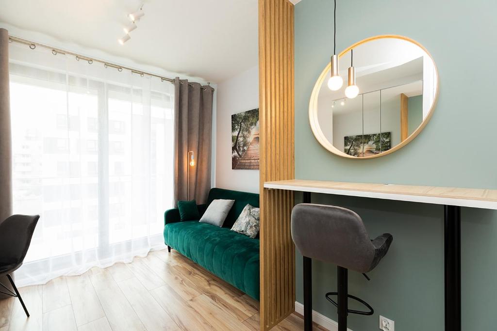 a living room with a green couch and a mirror at Cozy apartment Kazimierza 48, Wola in Warsaw