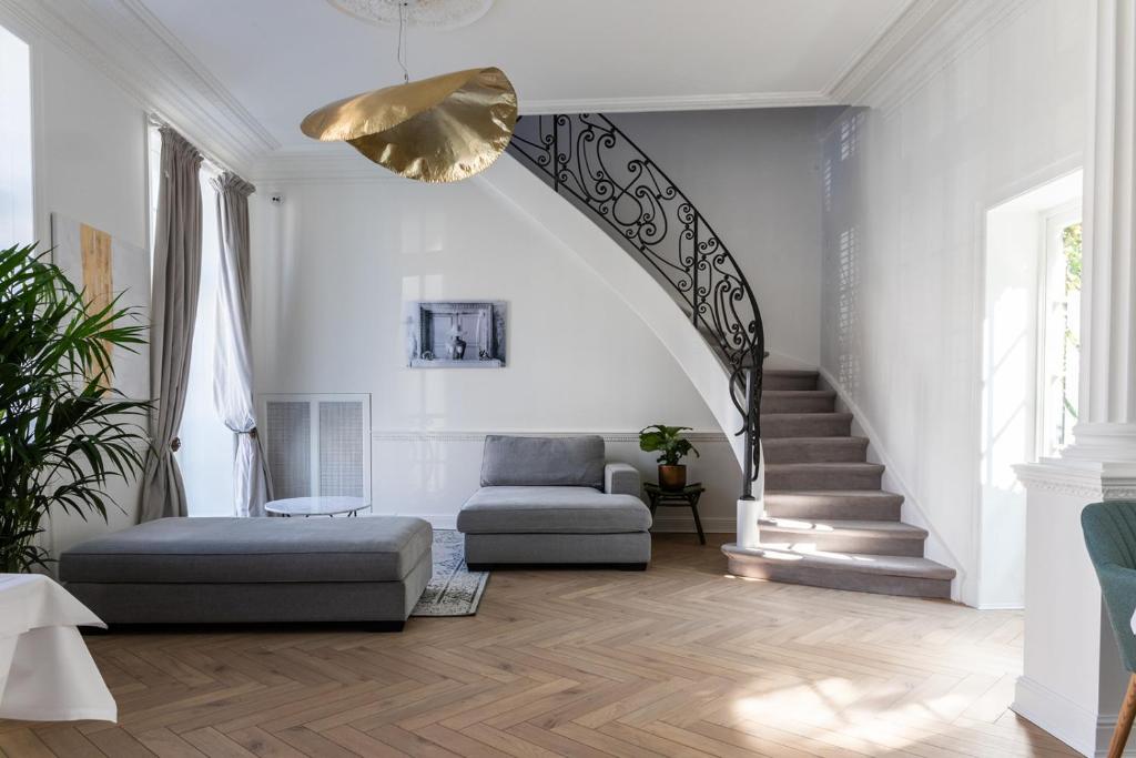 een woonkamer met een trap met een bank en een stoel bij Molenmeers Boutique Guesthouses in Brugge