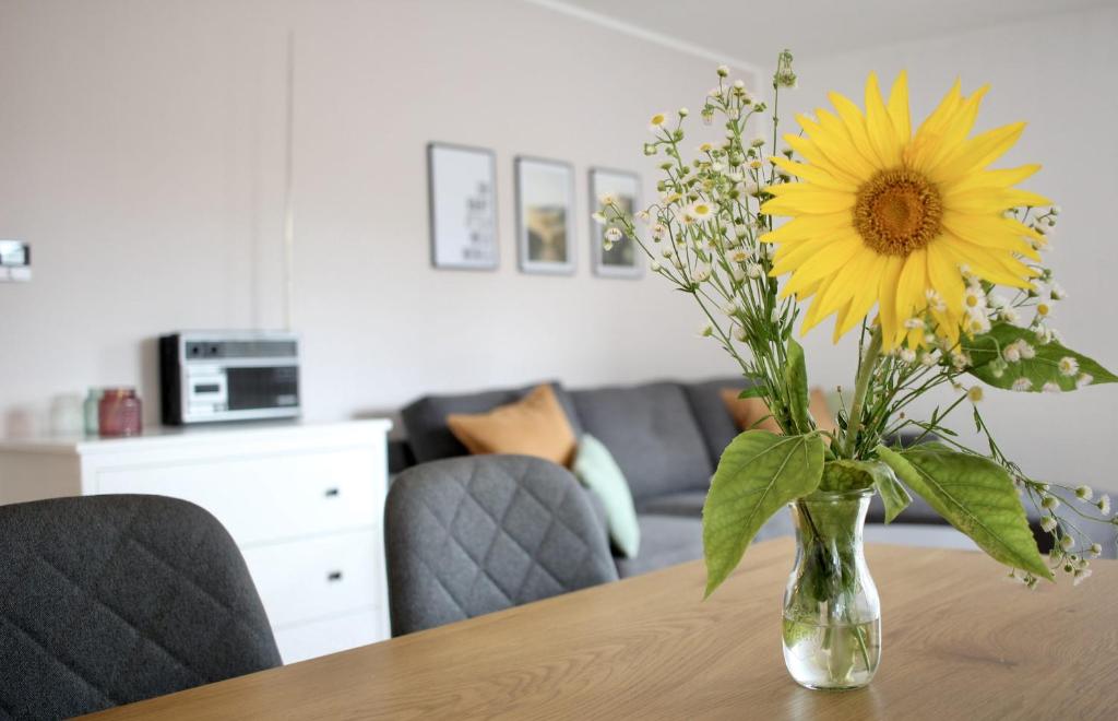 um vaso cheio de uma flor amarela sobre uma mesa em Ferienwohnung Morgensonne em Kenzingen