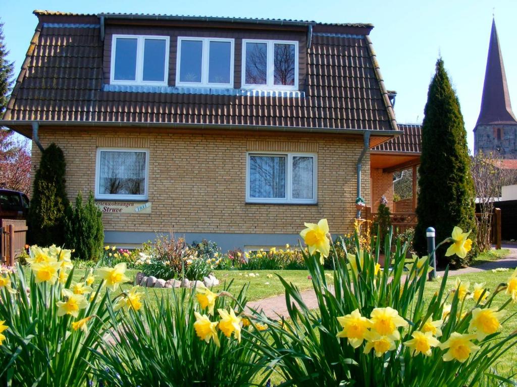 a house with yellow flowers in front of it at Ferienwohnung Struve Nr 2 in Petersdorf auf Fehmarn
