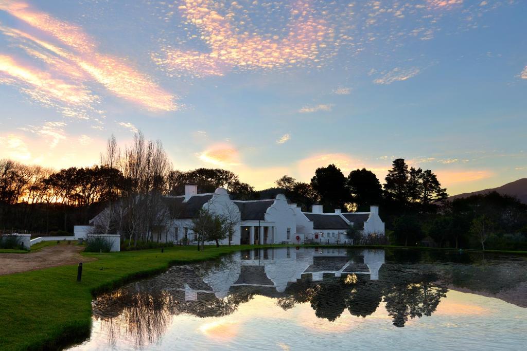 a house with a pond in front of it at Holden Manz Country House in Franschhoek