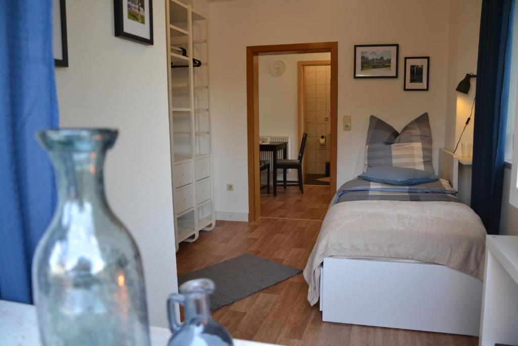 拜羅伊特的住宿－Ferienwohnung Kirsch 1，一间卧室,配有一张床和一张桌子上的花瓶