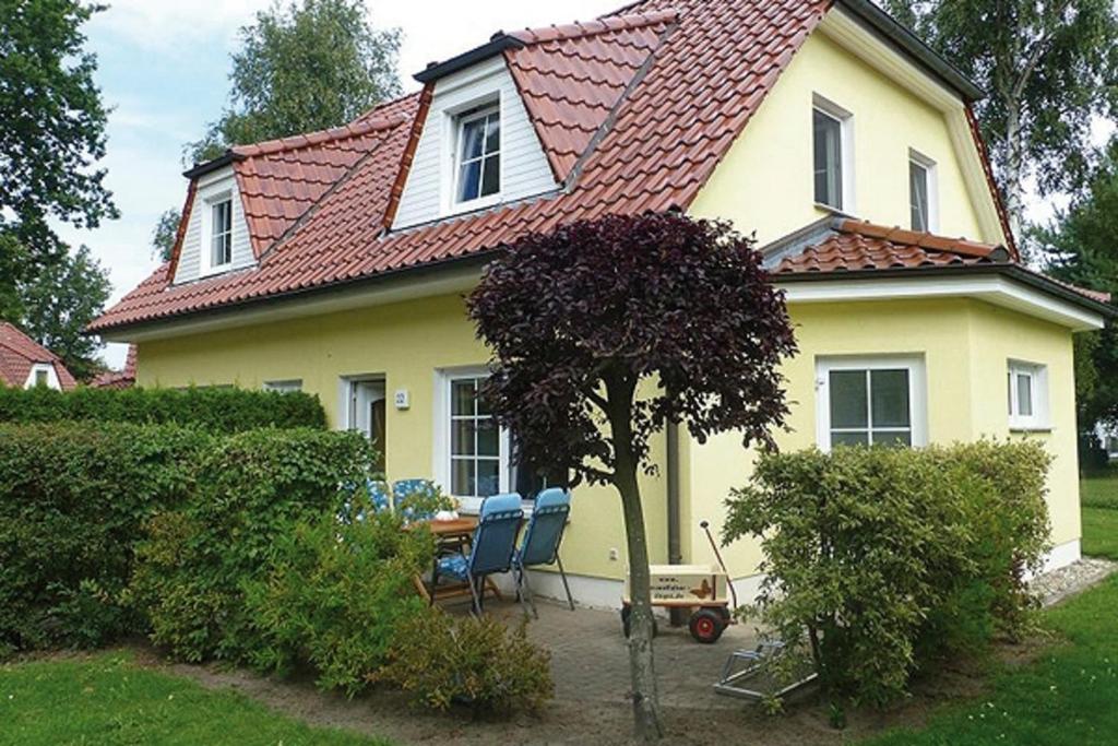 una casa amarilla con sillas delante en Am Deich 22 Strandfalter Zingst, en Zingst
