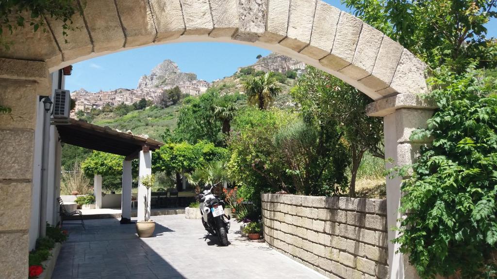 una motocicleta estacionada bajo un arco con una montaña en Casa Puccio B&B, en Caltabellotta