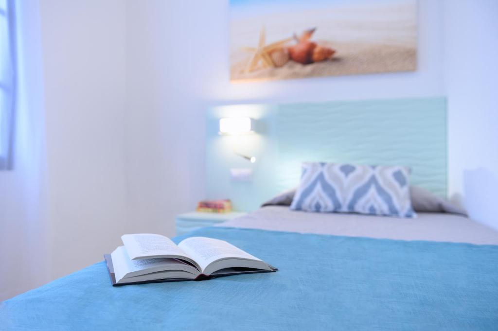 een open boek bovenop een bed bij Valle Marina Apartamentos in Mogán