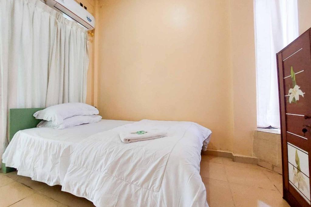 sypialnia z łóżkiem z białą pościelą i oknem w obiekcie Quattrick Dee Homestay Mitra RedDoorz w Manokwari