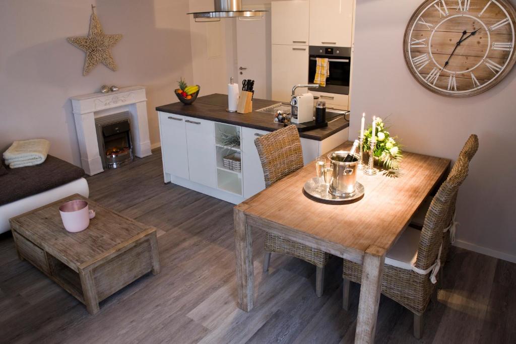 kuchnia i salon z drewnianym stołem i krzesłami w obiekcie Sunrise w mieście Grömitz