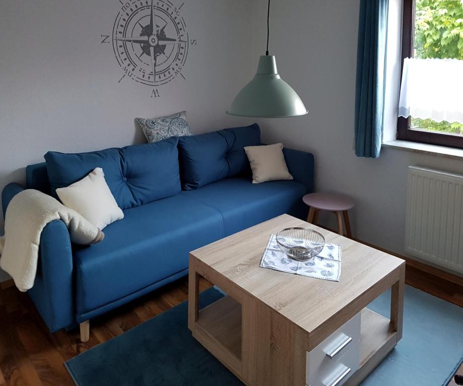 a blue couch in a living room with a table at Windrose - 95102 in Eckernförde