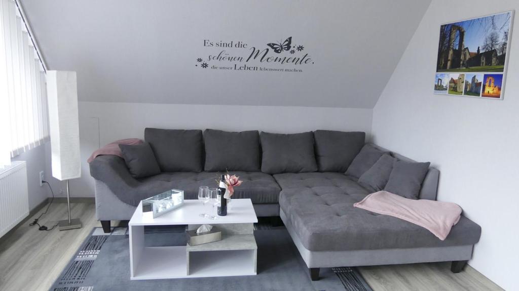 uma sala de estar com um sofá cinzento e uma mesa em Ferienwohnung Südharz em Walkenried