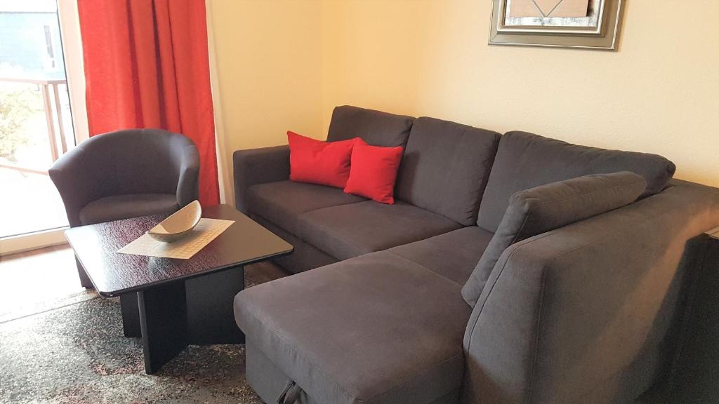 ein Wohnzimmer mit einem Sofa und einem Stuhl in der Unterkunft Deichkrone App 11 in Grömitz