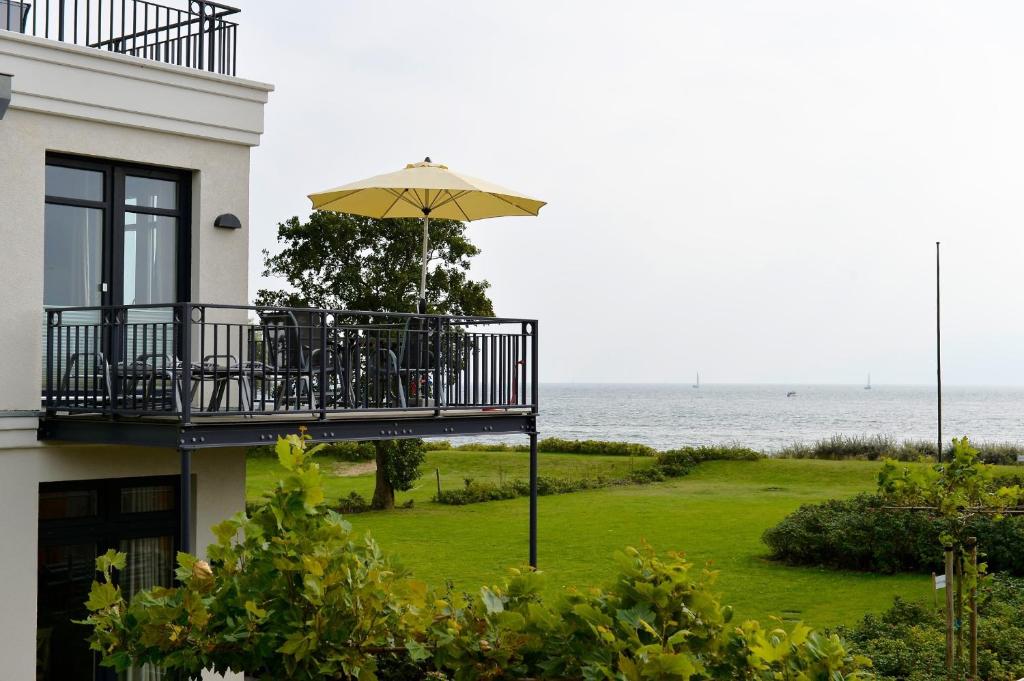 a balcony with an umbrella on top of a building at Fehmarn-Ostseeferien"Strandleev3" 1423 App 3 in Fehmarnsund