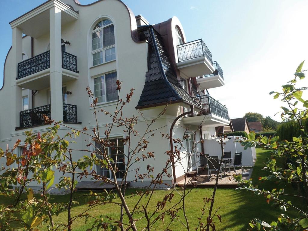 a white building with balconies and a yard at Strandresidenz Deichgraf 2 Prerow in Zingst