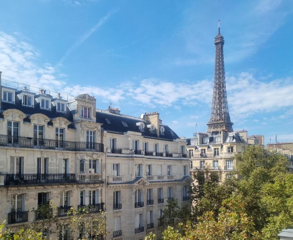 un bâtiment avec la tour eiffel en arrière-plan dans l'établissement Hôtel Eiffel Kensington, à Paris