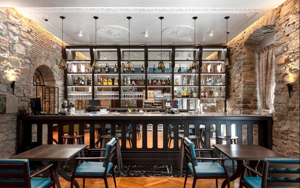 a restaurant with tables and chairs and a bar at Hotel Solun in Trieste