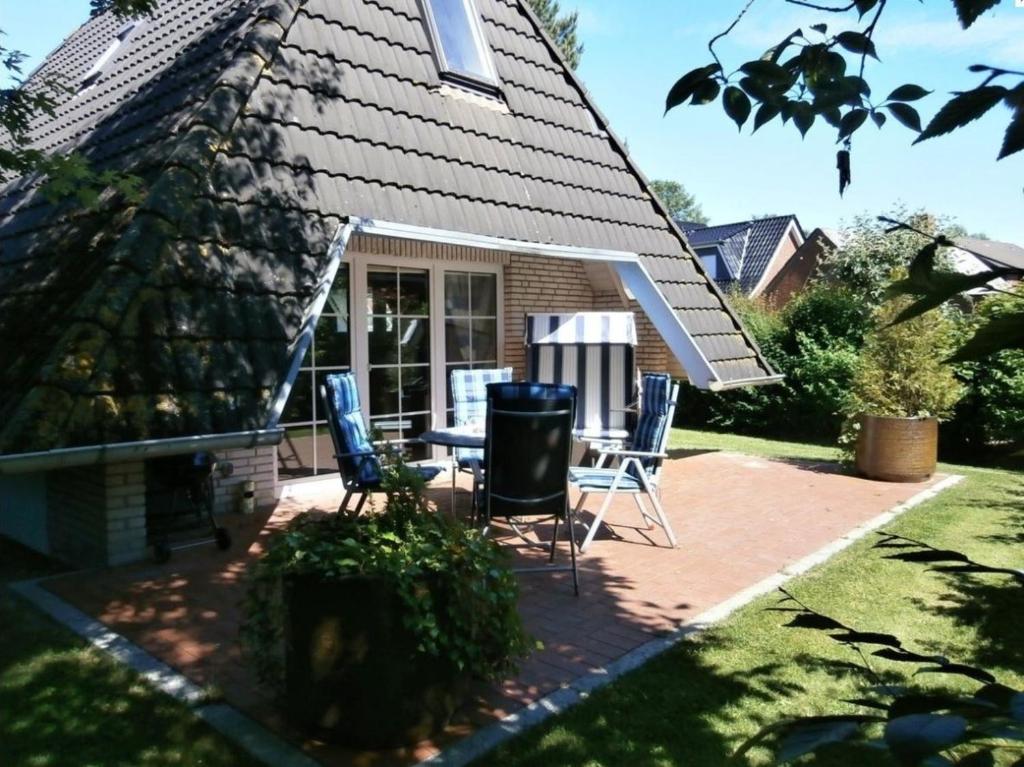 a patio with chairs and a table in front of a house at Dat Onnens Hus - Nordisch mit Herz in Dorum-Neufeld