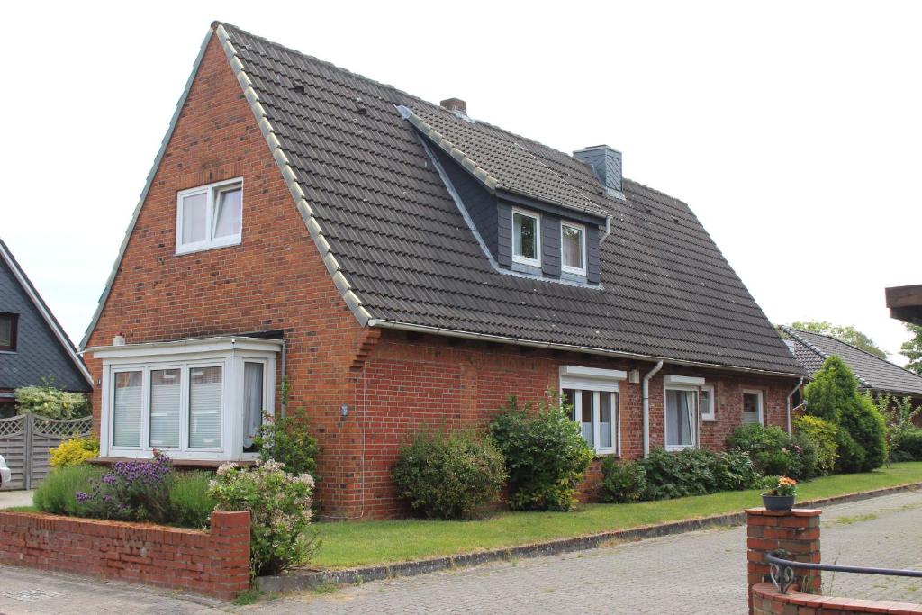 a red brick house with a black roof at Ferienwohnung Petersen I in Büdelsdorf