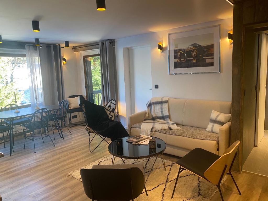 uma sala de estar com um sofá e uma mesa em Le FLOCON du Mont Darbois classé 3 étoiles em Megève