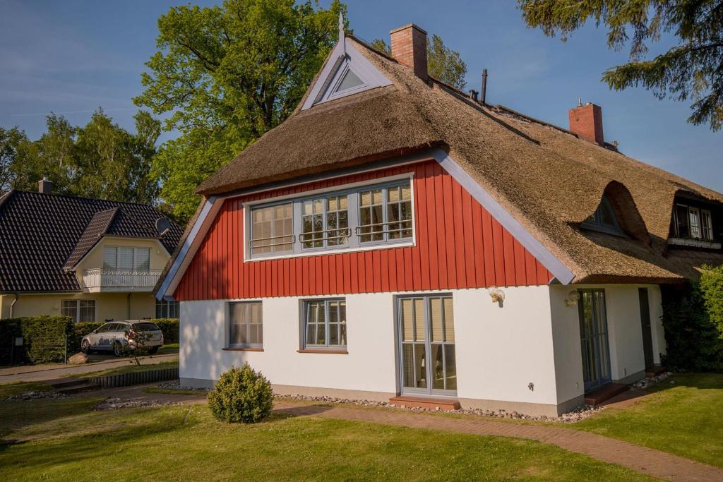 a red and white house with a thatched roof at Ostseebrise Reetdach 2 in Zingst