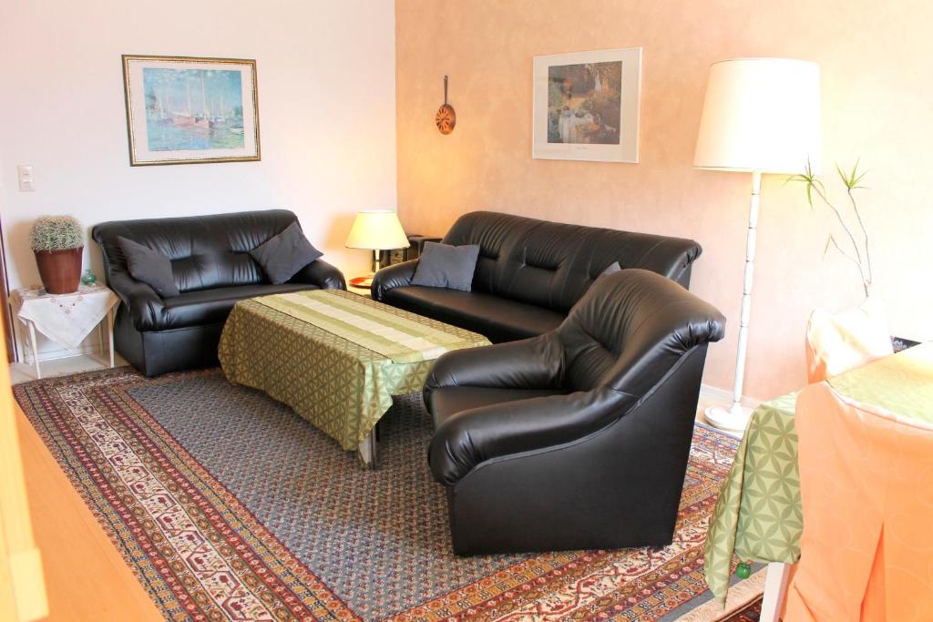 ein Wohnzimmer mit 2 Ledersesseln und einem Tisch in der Unterkunft Haus Strandfee - App 12 in Grömitz