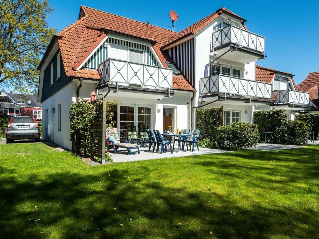 a large white house with a table and chairs at Birkenstraße 6 Haus I Whg 1 in Zingst