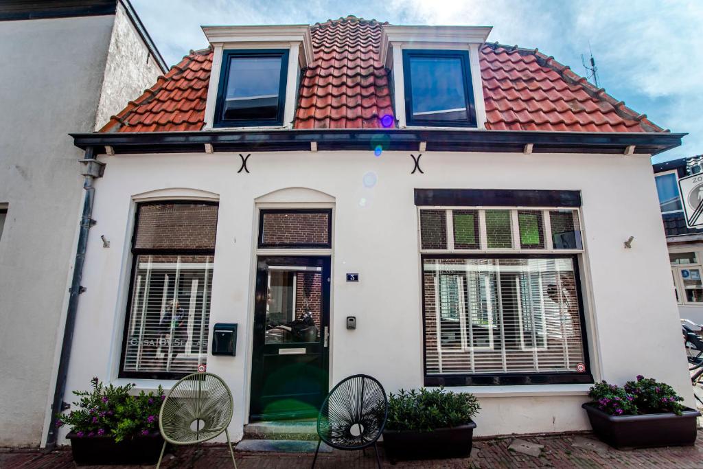 une maison blanche avec un toit rouge dans l'établissement Casa by Sellas, à Zandvoort