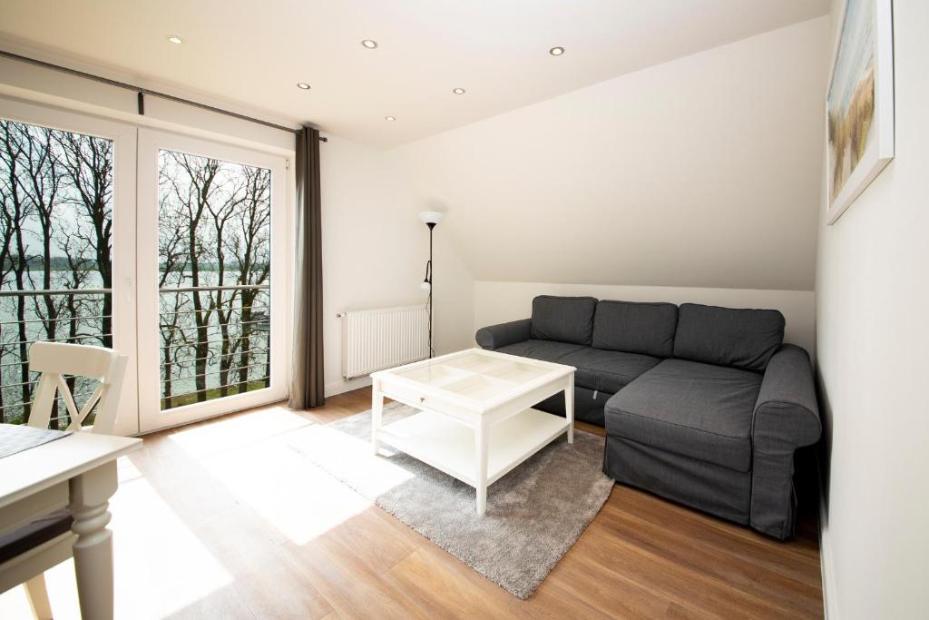 a living room with a couch and a table at Appartement Schleipanorama in Rabenkirchen-Faulück