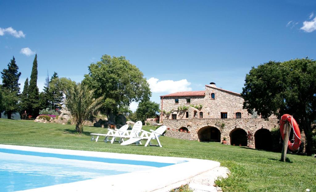 a resort with a swimming pool and a building at Can Palau in Agullana