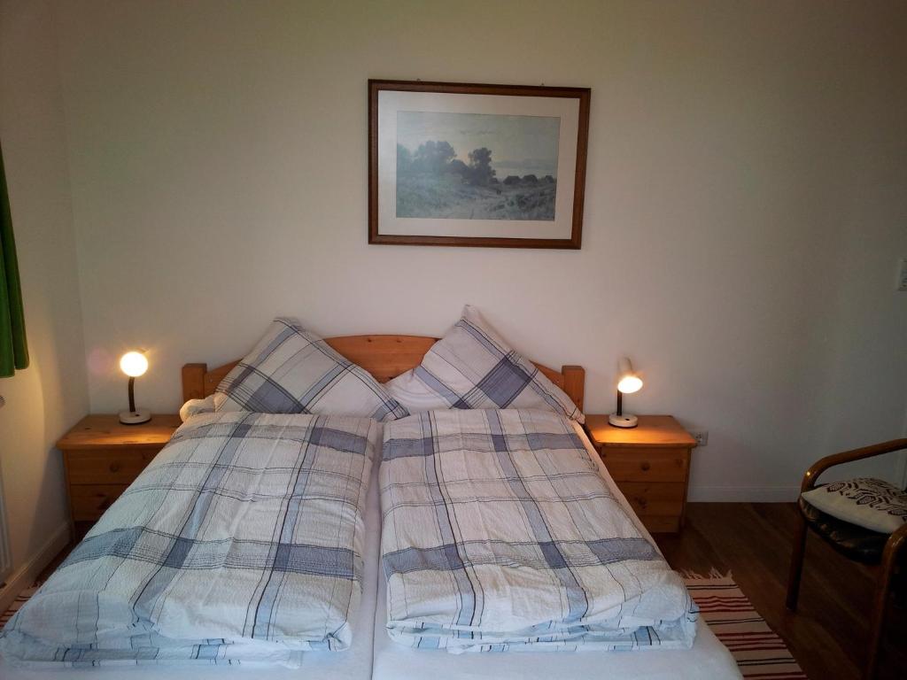 a bed with blue and white plaid sheets on it at "Höper Mittelhof" Doppelzimmer Nr4 in Lemkendorf