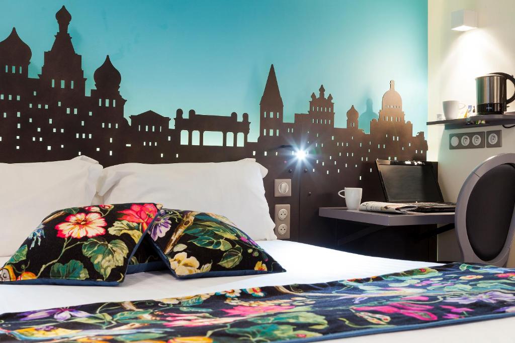 - une chambre avec un lit orné d'une fresque murale représentant la ville dans l'établissement Hôtel Aurore Paris Gare de Lyon, à Paris