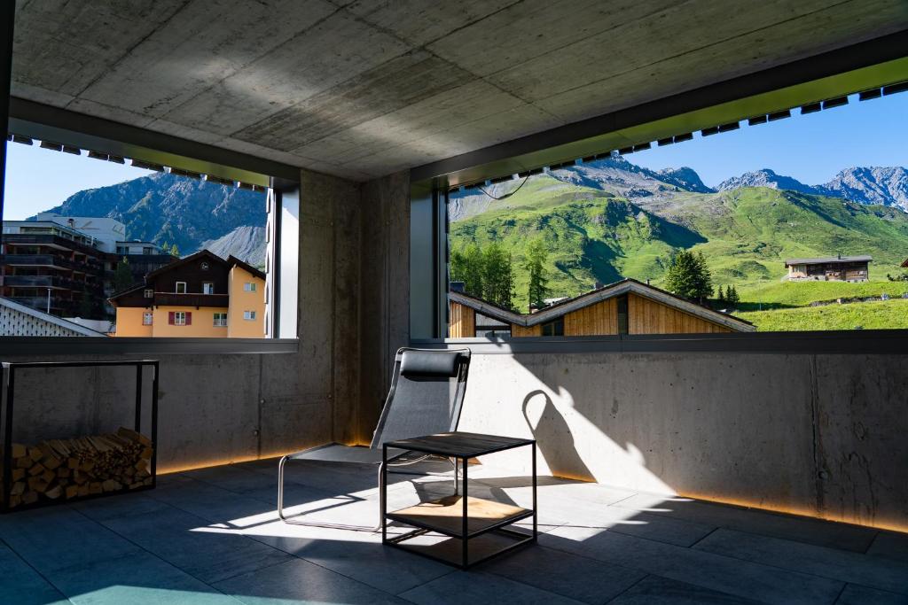 a chair on a balcony with a view of mountains at Mitti in Arosa