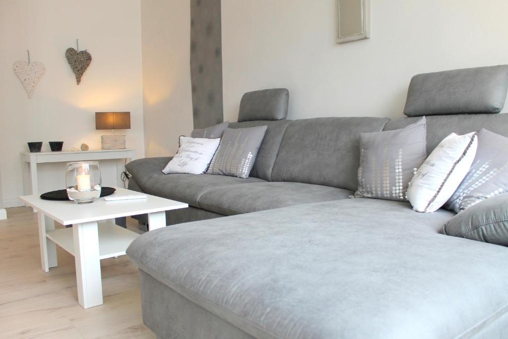ein Wohnzimmer mit einem Sofa und einem Tisch in der Unterkunft Tannenburg 203 - App Muscheloase in Grömitz