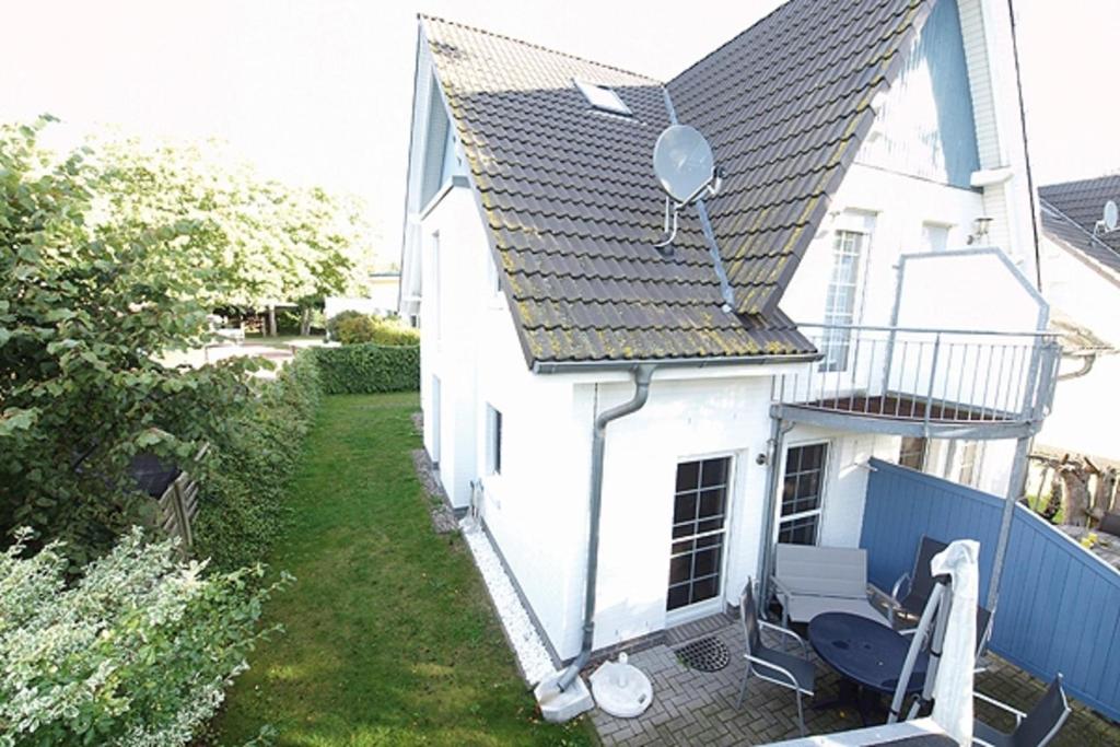 Biały dom z balkonem ze stołem i krzesłem w obiekcie Haus Regenbogen w Zingst