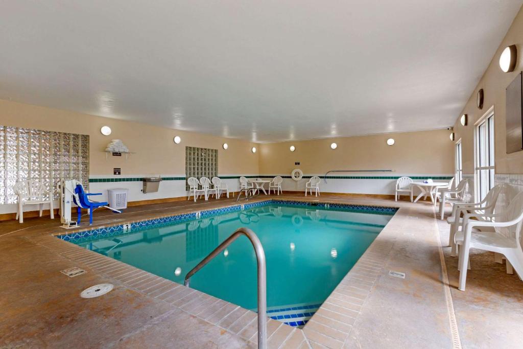 - une piscine dans une chambre d'hôtel avec des chaises et des tables dans l'établissement Comfort Inn Medford South, à Medford